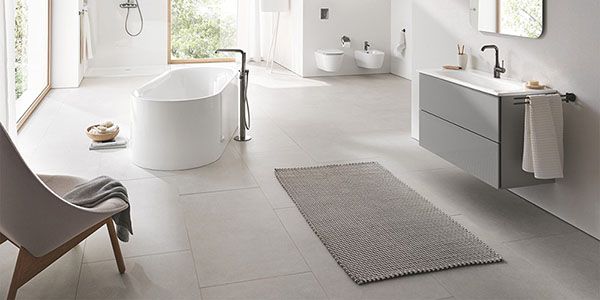 Ein modernes Badezimmer in Grautönen mit gefliestem Boden.